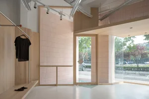 Modern retail storefront with wooden walls, glass doors, and tiled floor
