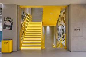 A modern interior with yellow stairs and concrete walls.
