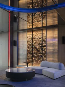A modern living room with concrete walls and a minimalist couch and table.