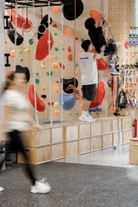 An indoor climbing wall with colorful wooden panels and climbing handles.