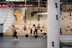 People exercising in a gym with wooden features and industrial design elements.