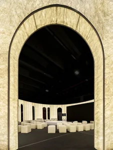A conference room with an arched entrance, textured fabric walls, and white seating arranged in a circle.