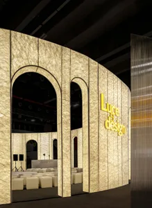 A curved, illuminated paper partition with lighting systems within the event space
