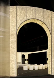 A fabric-covered archway with a stage setup in the background.