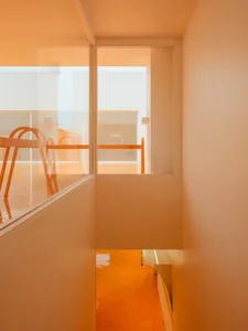 A modern interior space with an orange glass door and floor.