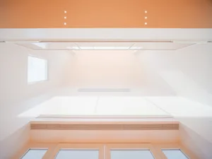 A modern interior space with white concrete walls and floors, white windows, and white ceiling.