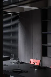 A minimalist dining room with black walls and furniture, showcasing sleek design and contemporary style.