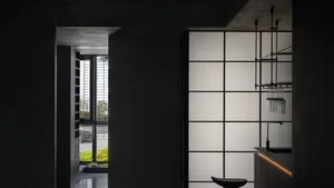 Modern residential kitchen featuring glass cabinets, minimalist design, and sleek black fixtures.