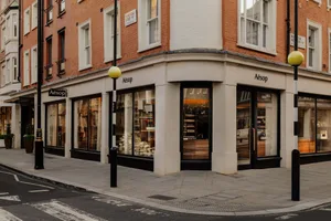 A modern retail storefront with glass windows, stone accents, and wooden materials.