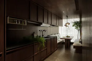A minimalist kitchen with dark wood cabinets, green plants, and a table with a bowl of fruit.