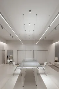 A sleek, minimalist restaurant interior with a polished concrete dining area featuring a long, rectangular table and contempo