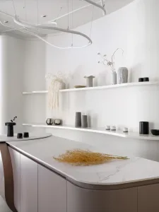Modern kitchen interior with marble countertop and concrete floor.