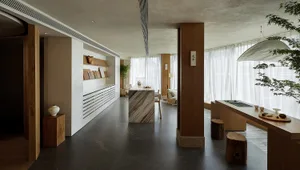 A modern showroom featuring a kitchen display with marble countertops and wooden accents.