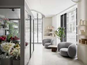 Modern minimalist spa interior with concrete, glass, and wooden materials, featuring comfortable seating and tranquil decor.
