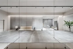 Minimalist installation featuring glass panels on a metallic floor and white walls.