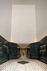 A modern lobby with marble walls and floor, featuring a geometric pattern and detailed finishes.