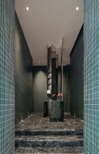 Modern hotel lobby with marble floors and walls, featuring a sleek reception desk area.