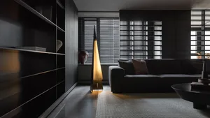Modern living room with dark furniture and contemporary lighting.