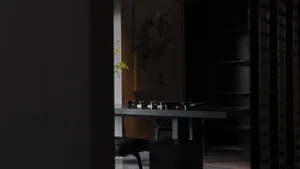 A minimalist tea room with dark wooden furniture and a simple teapot and cups arrangement.