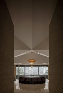 Modern dining room featuring a concrete ceiling and walls with a round dining table surrounded by chairs.