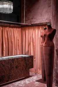 Luxurious retail store display featuring velvet curtains and mannequins.
