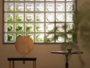 A minimalist interior featuring a window with glass block wall design.