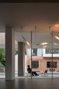 A minimalist public space featuring modern glass and brick elements.