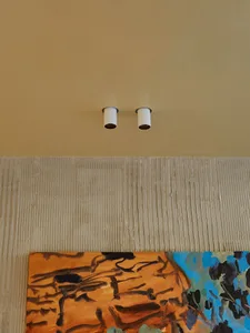 A modern art display featuring abstract paintings mounted on a textured concrete floor.