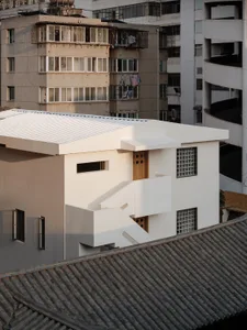 A modern concrete building with a minimalist design and clean lines, featuring large windows and a flat roof.