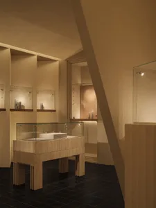 A modern exhibition space with a glass display case containing a white object.