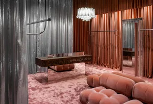 A modern fashion retail store featuring metallic textiles and a futuristic design.