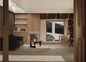 Modern living room with wooden furniture and a black couch.