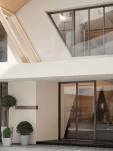 A modern lobby with glass walls and a geometric ceiling design.