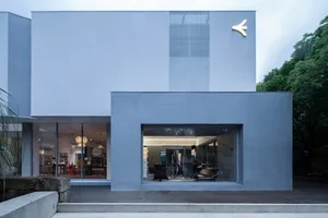 Modern minimalist storefront with metallic facade and large glass windows.