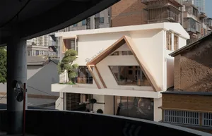 A modern urban residential house with concrete exterior and glass windows.