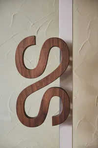 A modern wooden lettering design with a dark brown finish.