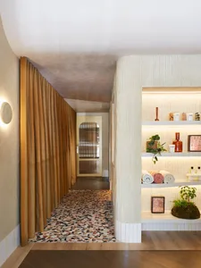 A spa interior with a faux marble texture wall and shelves displaying spa products.