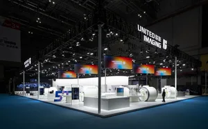 United Imaging exhibition booth with illuminated signage and various electronic devices.