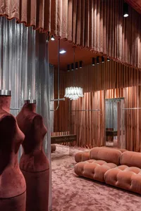 A retail store interior featuring plush velvet curtains and a modern chandelier.