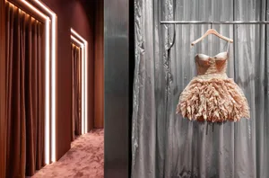 A fashion dress displayed on a hanger in a room with gray curtains and lit pathways.
