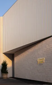 Modern storefront with metal siding and a glowing sign reading "maison joseph"