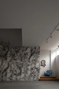 A modern living space with marble walls and a concrete floor