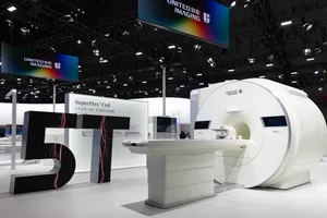 A modern medical device exhibit showcasing a white MRI machine with a futuristic design.