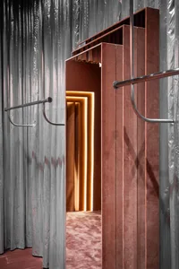 Modern interior design featuring a metal and velvet clothing store display.