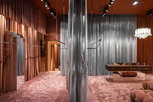 A retail storefront with velvet curtains and a pink carpet.