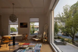 Interior design of a modern living room with wooden flooring, large windows, and a clear view of the outdoors.