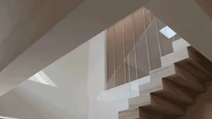 Concrete staircase with wooden railings and a skylight