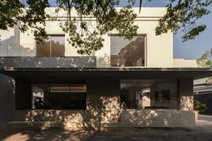 A modern building featuring concrete exterior and large glass windows.