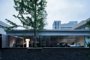 Modern residential home with large glass walls and rooftop garden.