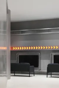A minimalist office waiting area featuring metallic finishes, a sleek design, and a seating area.